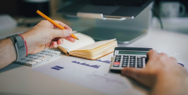 Hand with pencil and calculator